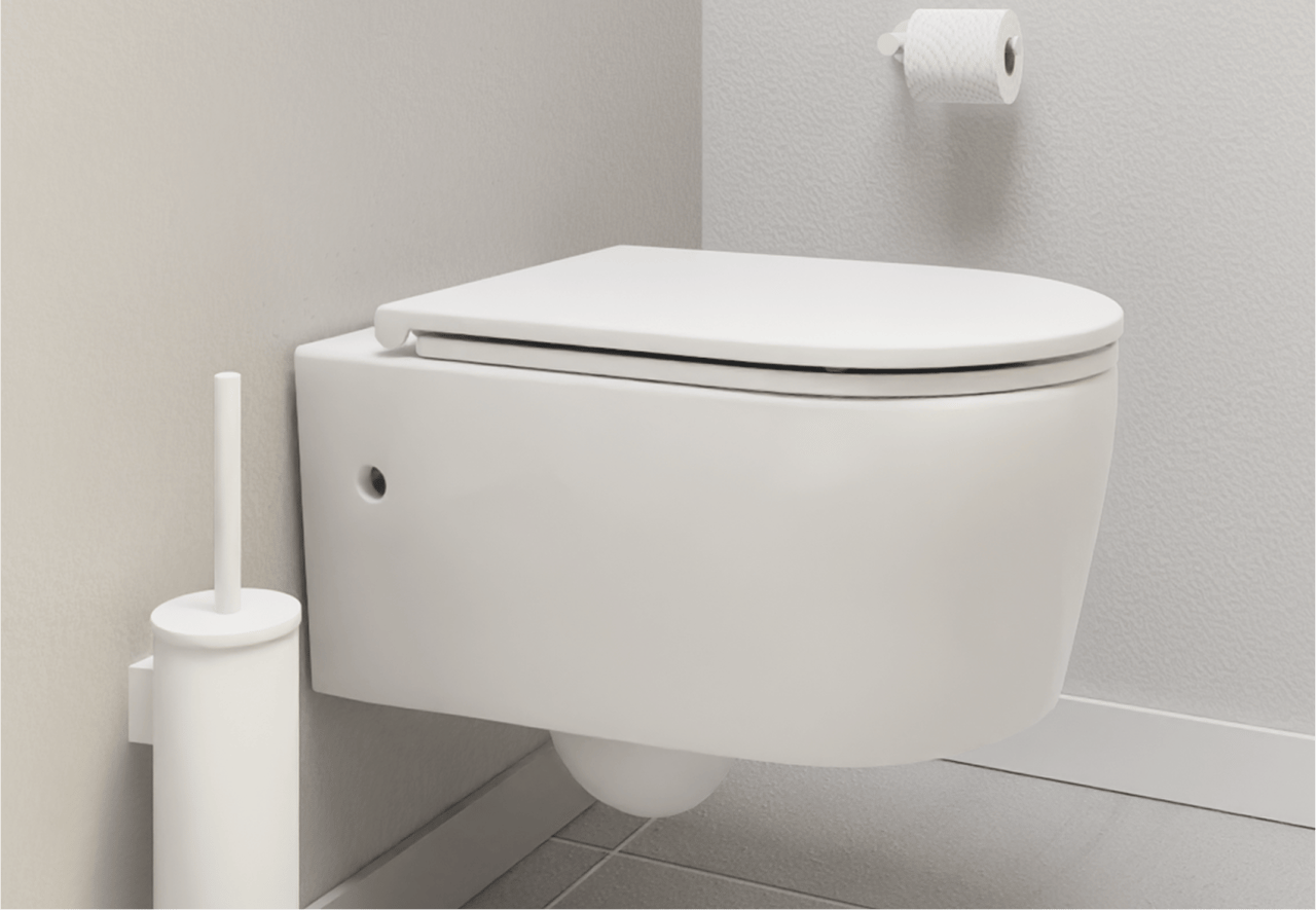 Witte hangwc met gesloten deksel tegen een lichtgrijze wand. Links een witte toiletborstel, rechts een wc-rol. Praktisch design van x²o badkamers.